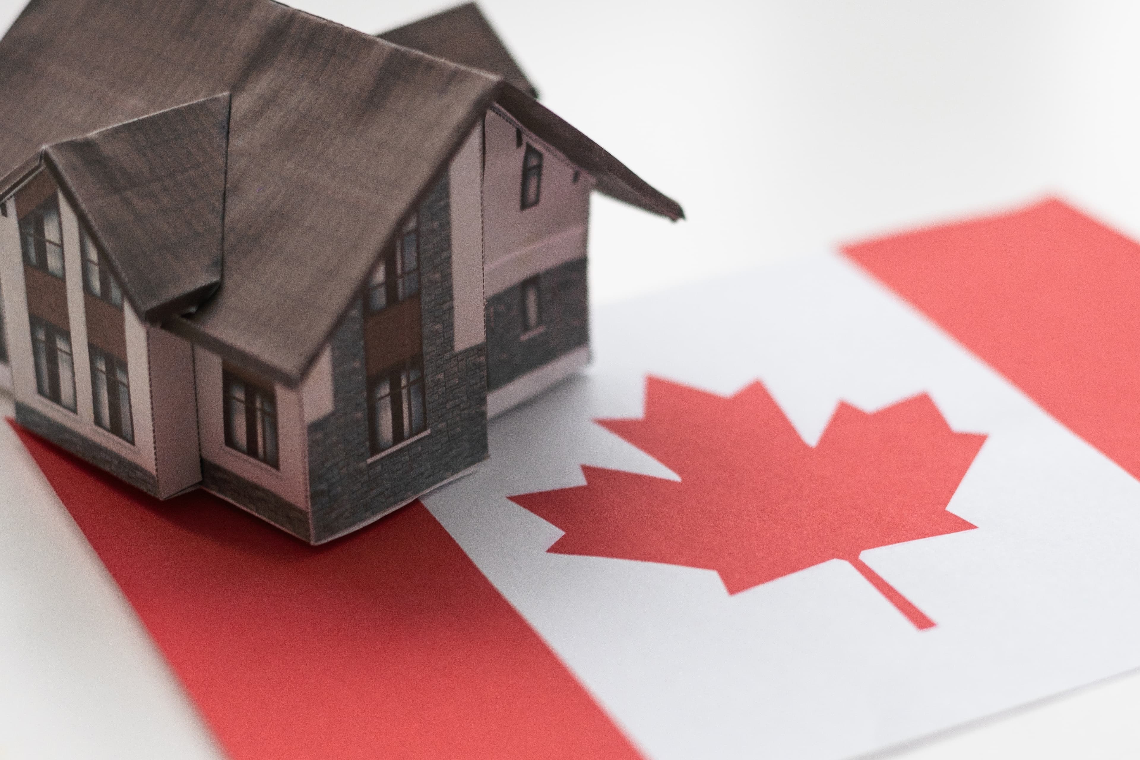 Miniature house model on Canadian flag.