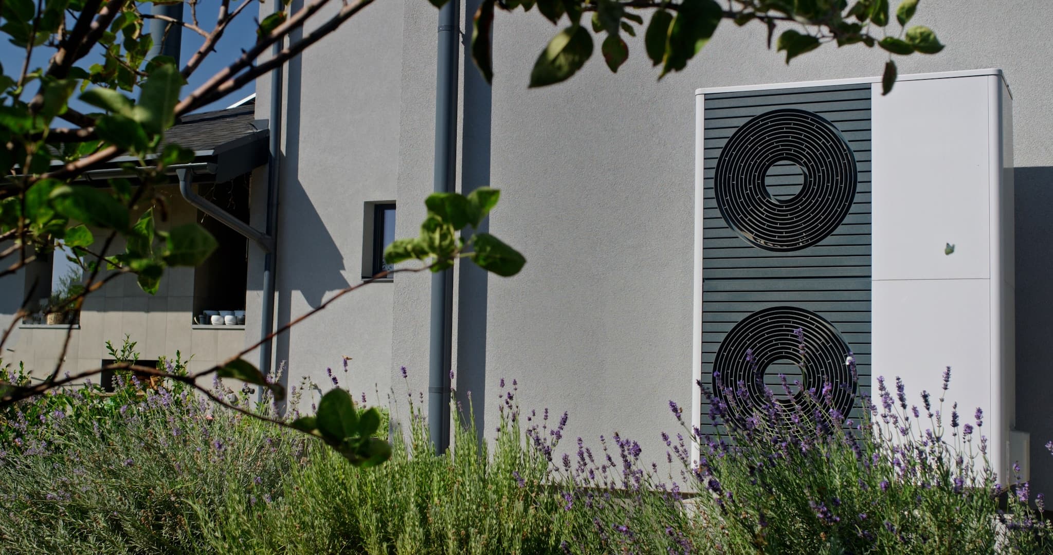 Exterior of modern house with air source heat pump and garden.