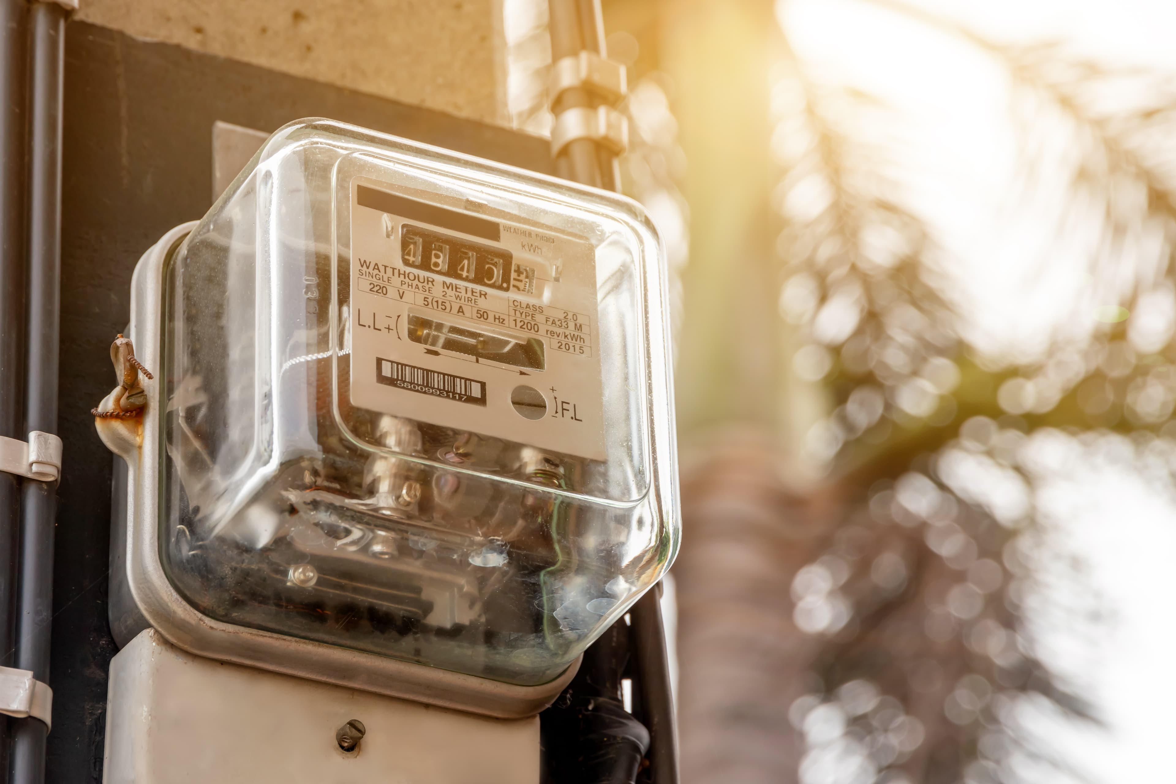 Outdoor electricity meter close-up with sunlight.