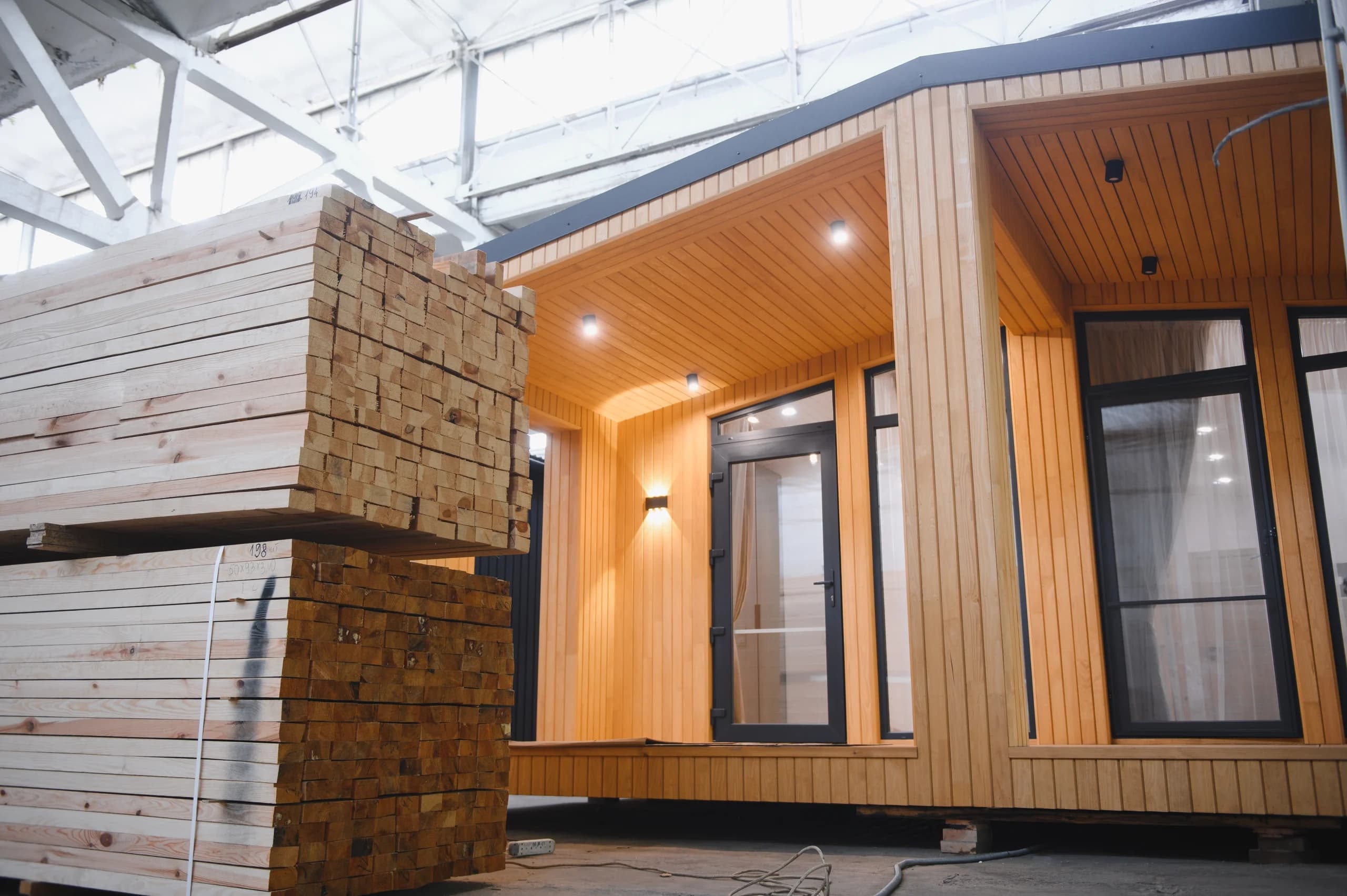 Prefabricated wooden home with modern design in a warehouse.