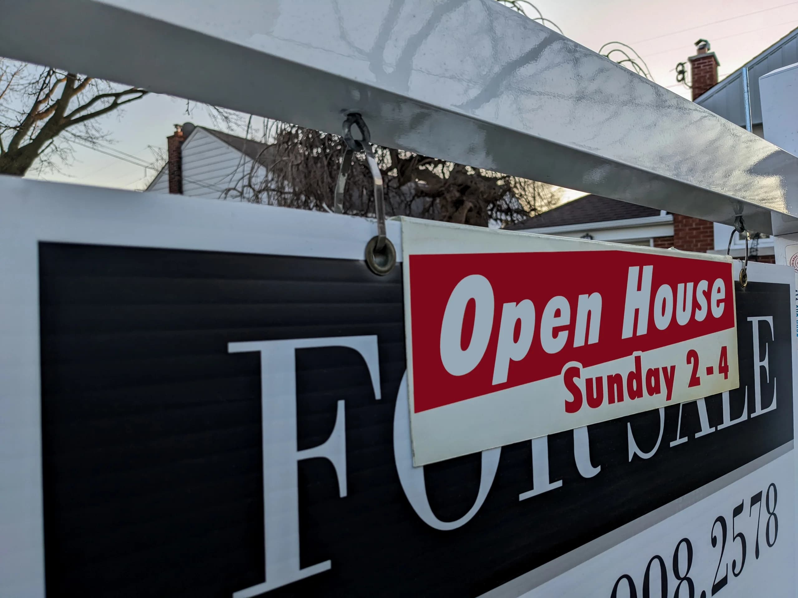Close-up of open house sign for a real estate property.