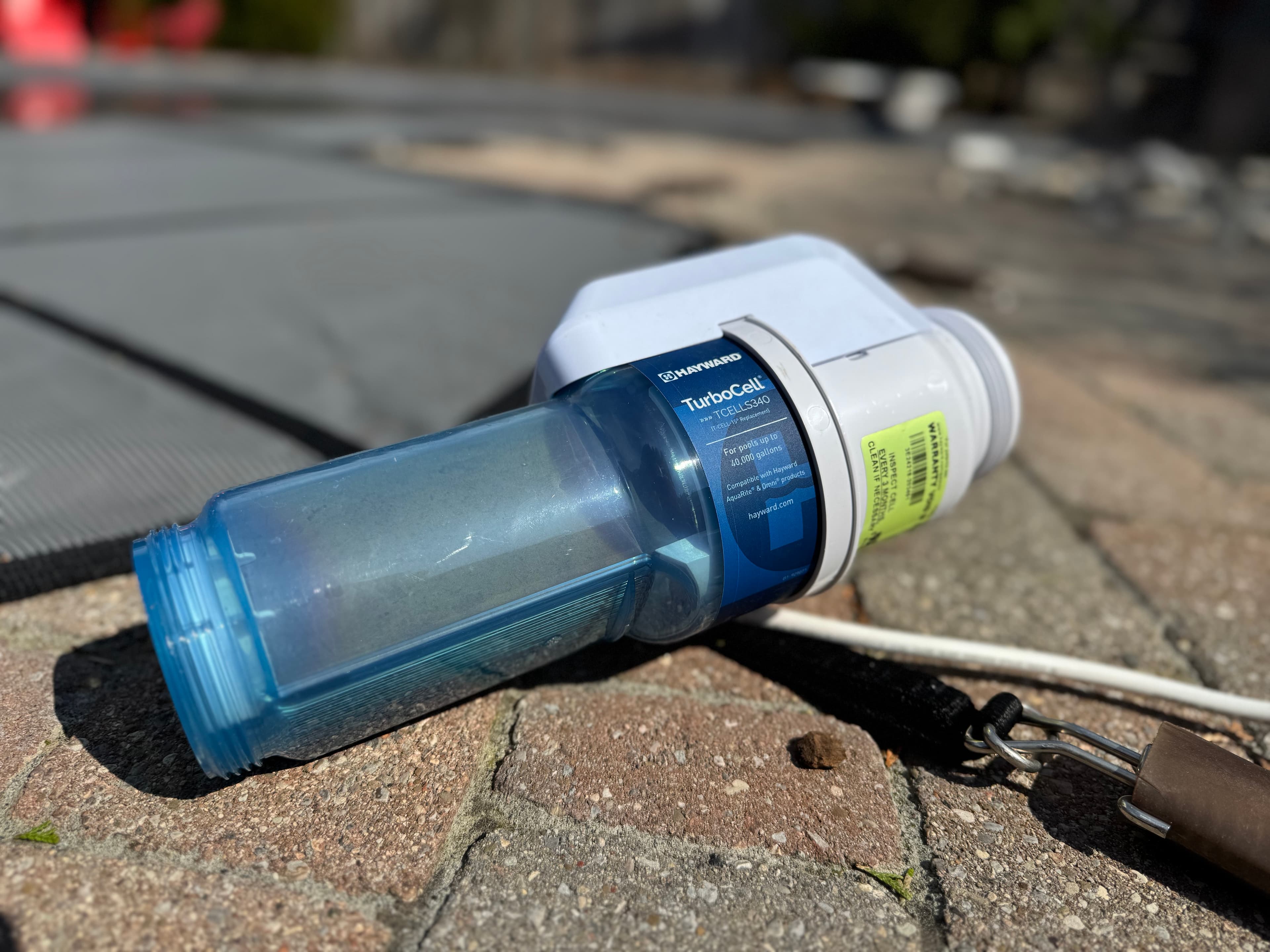 Hayward TurboCell salt cell on paved ground in sunlight.