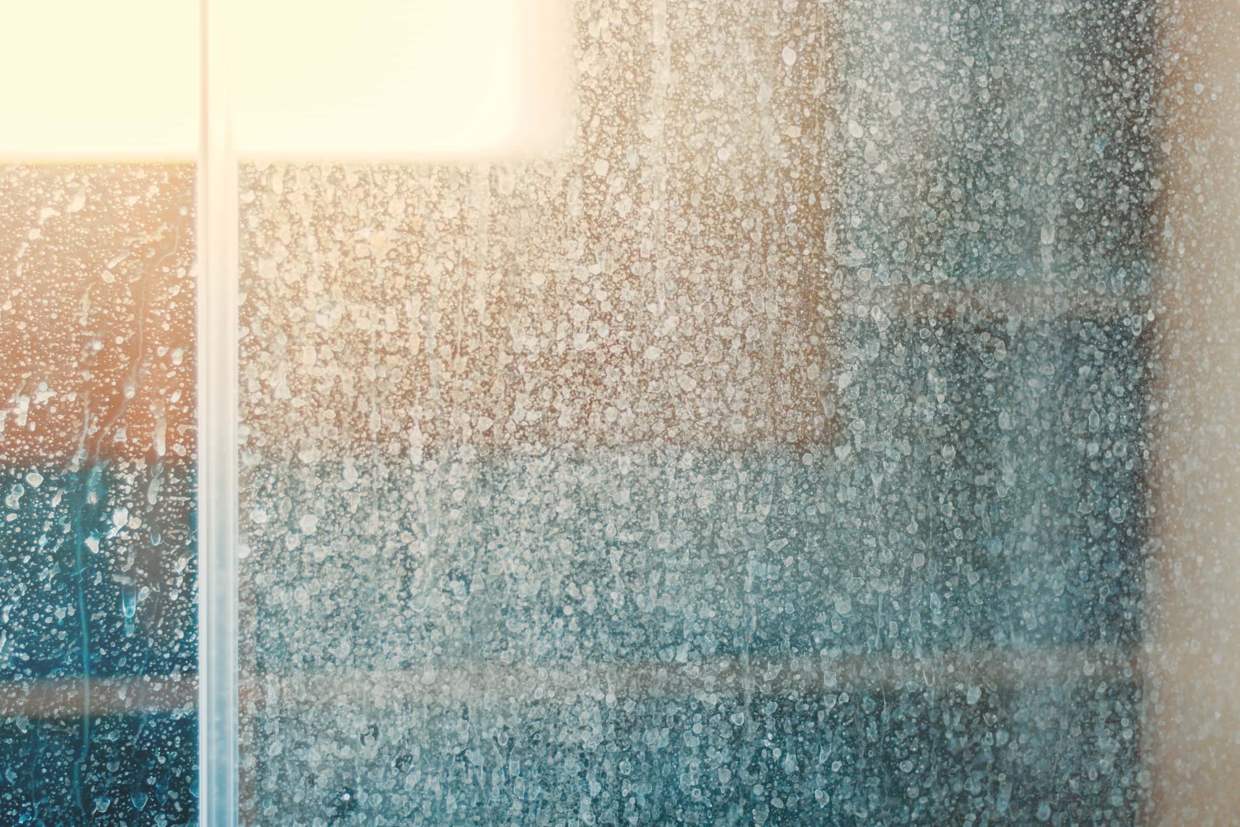 Close-up of hard water stains on glass with soft lighting.